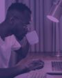 Na imagem, homem negro utilizando um computador